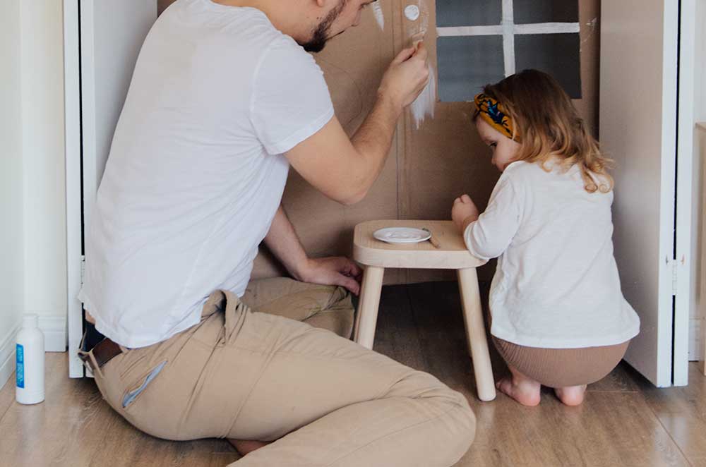 man in white t shirt and brown pants painting cardboard 3933227