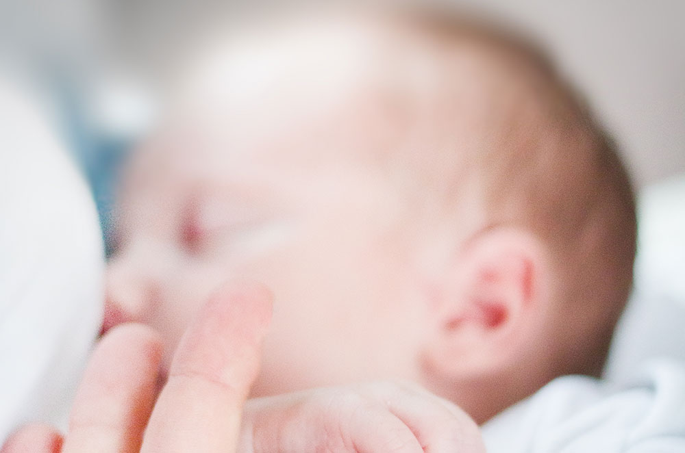 tilt shift lens photo of infant s hand holding index finger 895515